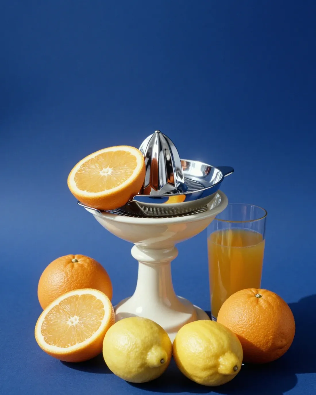 Un presse-agrumes chromé, des oranges éclatantes et un verre de jus sous un soleil dur : du concentré d’énergie